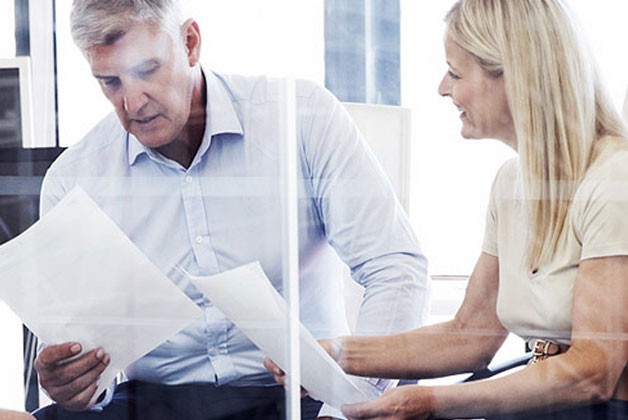 a man and a woman looking at a paper